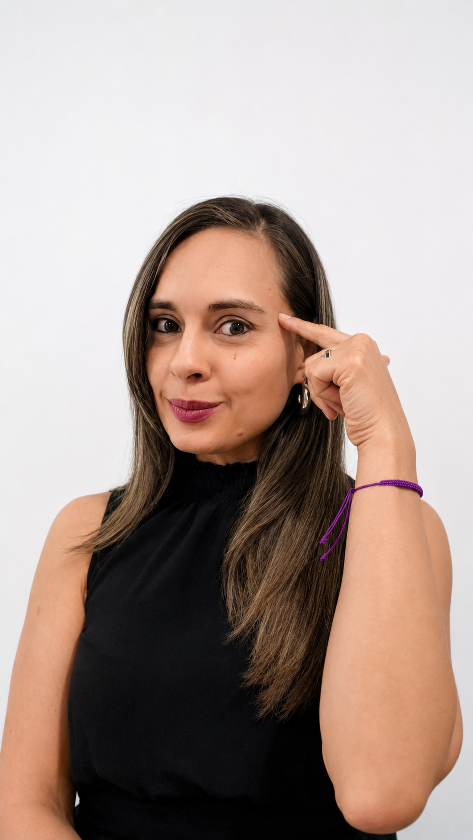 Paula Ledesma sonriendo, sentada junto a una obra de arte morada